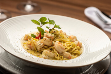Shrimp creamy italian pasta on plate and wooden table