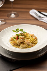 Shrimp creamy italian pasta on plate and wooden table