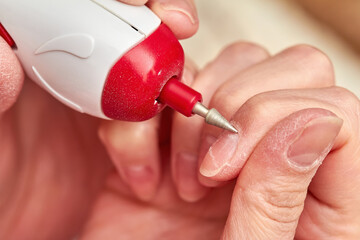 Woman filings nails with electric nail file at home. Electric Nail File Manicure Pedicure Drill....