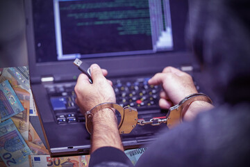 Hands of arrested hacker in handcuffed. Prisoner or arrested terrorist, closeup of hands in handcuffs, selective focus. Spam and viruses for the euro.