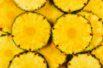 Pineapple juicy yellow slices background. Top view.