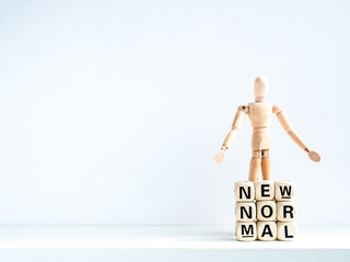 New Normal, words on wooden alphabet cube and wooden figure.
