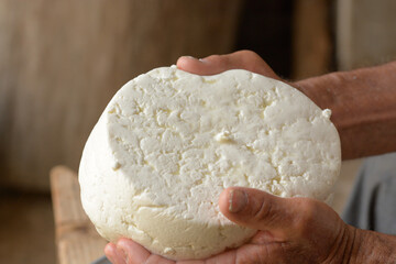 Shepherd`s hands the shape of the cheese. After following the cheese production process, the shepherd takes the product with its typical shape from the container and begins the drying and seasoning ph