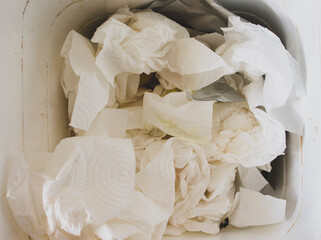 Trash bin with too mush paper trash, White tissue paper in bin.
