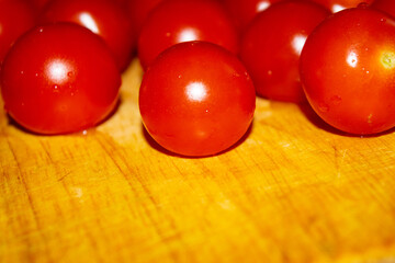 Small red cherry tomatoes on a wooden Board. Close up.