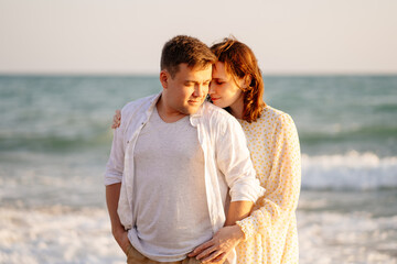 couple stand on shore line, sandy beach. romantic relationship, travel together.