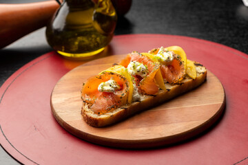 Salmon with mango bruschetta on wooden board leather place mat