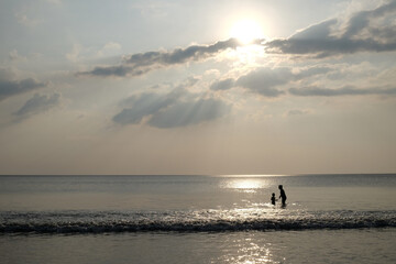 siluet of family on the beach and beach before sunset
