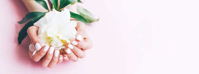 Banner for the site with a female white manicure and peony.