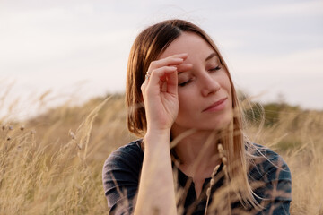 Young woman, portrait enjoying nature and freedom in a golden field