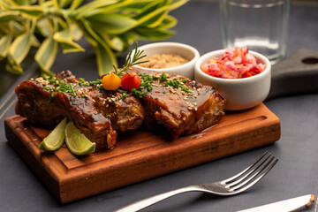 Ribs on barbecue on a wooden board with a blurred background