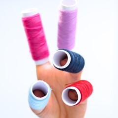 Threads. Threads in spools are worn on fingers.