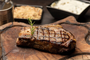 steak on a wooden board with a blurred background with side dishes