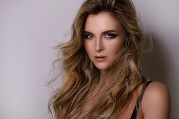 Fototapeta premium Gorgeous woman with a beautiful curly hair and professional makeup