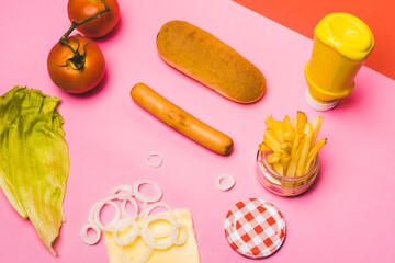 set of hot dog ingredients on a pink background