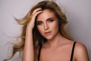 Gorgeous woman with a beautiful curly hair and professional makeup