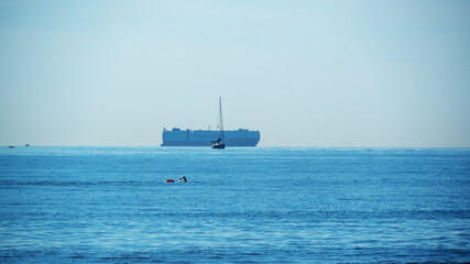 a container ship boat swimmer and  blue sea