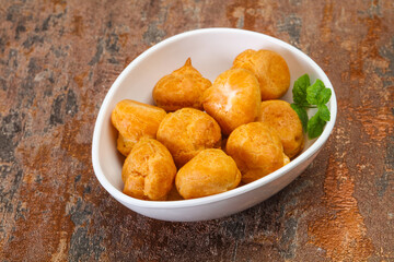 Sweet tasty profiteroles heap in the bowl