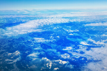snowy mountains and clouds view from airplane