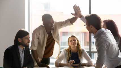 Horizontal banner multi-ethnic teammates giving high five joining palms while colleagues looking at them feels proud, sharing common success, support, loyalty, racial equality and leadership concept - obrazy, fototapety, plakaty
