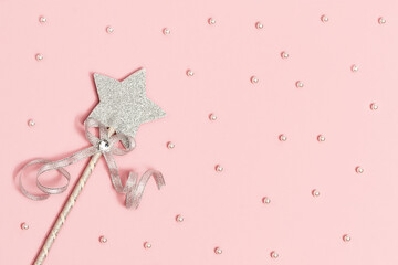 Festive decoration, bright silver star with sequins on soft pink background with white beads. Minimal holiday concept. Flat lay.