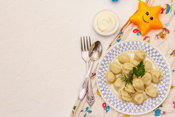 Hot meat dumplings with fresh sour cream. Homemade healthy kid's food, funny toys
