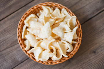 prawn crackers chips on basket and wooden table background - homemade crunchy prawn crackers or shrimp crisp rice for traditional snack