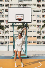 Young stylish woman  is posing on the Choi Hung Estate Basketball Court