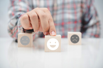 worker hand pick up the smiley wood cube block