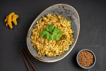 Kichari decorated with parsley leaves next to cardamom and turmeric top view