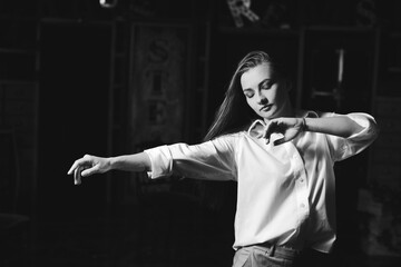 Black and white portrait of beautiful dancing caucasian girl with dramatical emotion on the stage.Retro fashion. Black and white image.