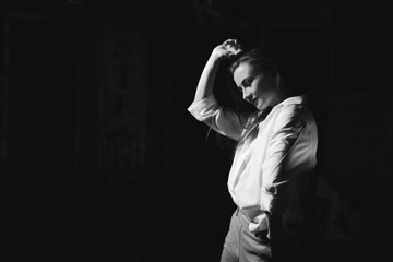 Black and white portrait of beautiful dancing caucasian girl with dramatical emotion on the stage.Retro fashion. Black and white image.