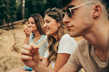 Young people eating potato chips.