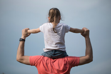 Family values. Father and daughter meet the sunset. He will put the girl on his shoulders and hold her hands. Fathers day concept.