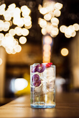 A refreshing iced long drink with grapes and strawberry at the bar