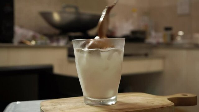 Making Dalgona coffee, a frothy coffee made by instant coffee, sugar, hot water and milk.