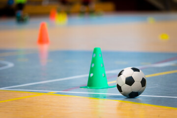 Futsal practice pitch. Indoor soccer ball and training equipment on the wooden floor. Football...