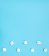 Naklejka premium Delicious white merengues on blue background. Happy day, breakfast, good morning concepts. Time for tea or coffee. Greeting or invitation card. Flat lay style with copy space.