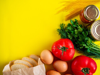Food supplies on yellow background, top view with copy space