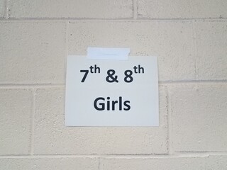 paper 7th and 8th girls sign on white cement wall