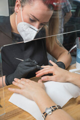 mujeres trabajando en centro de belleza, estética y bienestar con las mascarillas y EPIS reglamentarios por el virus COVID-19