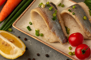 herring fillet on a plate with onions and vegetables