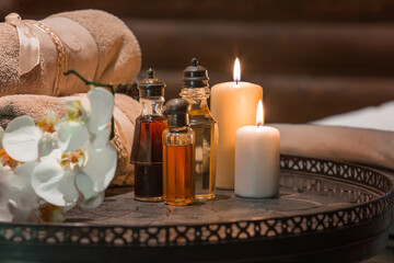 Different massage oils in vintage antique bottles with candles at spa. Dark surface. aromatherapy. Nobody