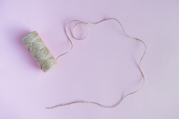 Jute twine on the purple background. View from top, copy space. 