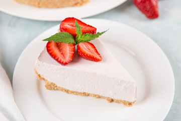 Sweet breakfast, delicious cheesecake with fresh strawberries and mint, homemade recipe without baking, on a blue stone table. Copy space.