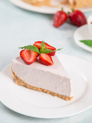 Sweet breakfast, tea and delicious cheesecake with fresh strawberries and mint, homemade recipe without baking, on a blue stone table. Copy space.