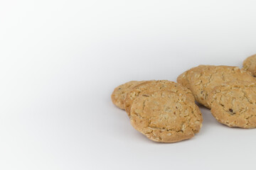Closeup cereal cookies are arranged in multiple pieces and have three rows, and the cookies are brown and the image has a blank area next to the object and has a white background.
