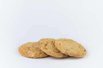 Closeup cookies are arranged in multiple pieces, stacked together, and the cookies are brown and the image has blank space beside the object and has a white background.
