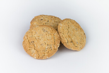 Closeup cookies are arranged in multiple pieces, stacked together, and the cookies are brown and the image has blank space beside the object and has a white background.