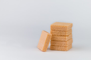 The orange-flavoured wafer Closeup is arranged on top of many pieces and the wafer has an orange colour. The image has blank space beside the object and has a white background.